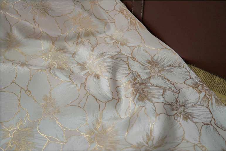 Tissu jacquard à broderie florale dorée : 162,5 cm de large. Idéal pour l’ameublement, les costumes et les rideaux. Vendu au mètre.