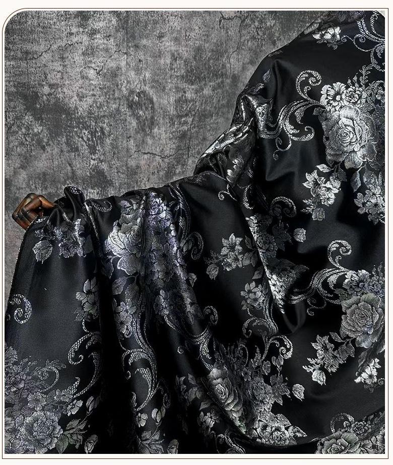 Tissu brocart jacquard noir : motif floral blanc nacré en relief, 150 cm de large