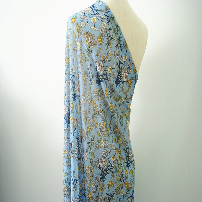 Crêpe bleu lac chrysanthème : 150 cm de large, satin de polyester, vendu au mètre