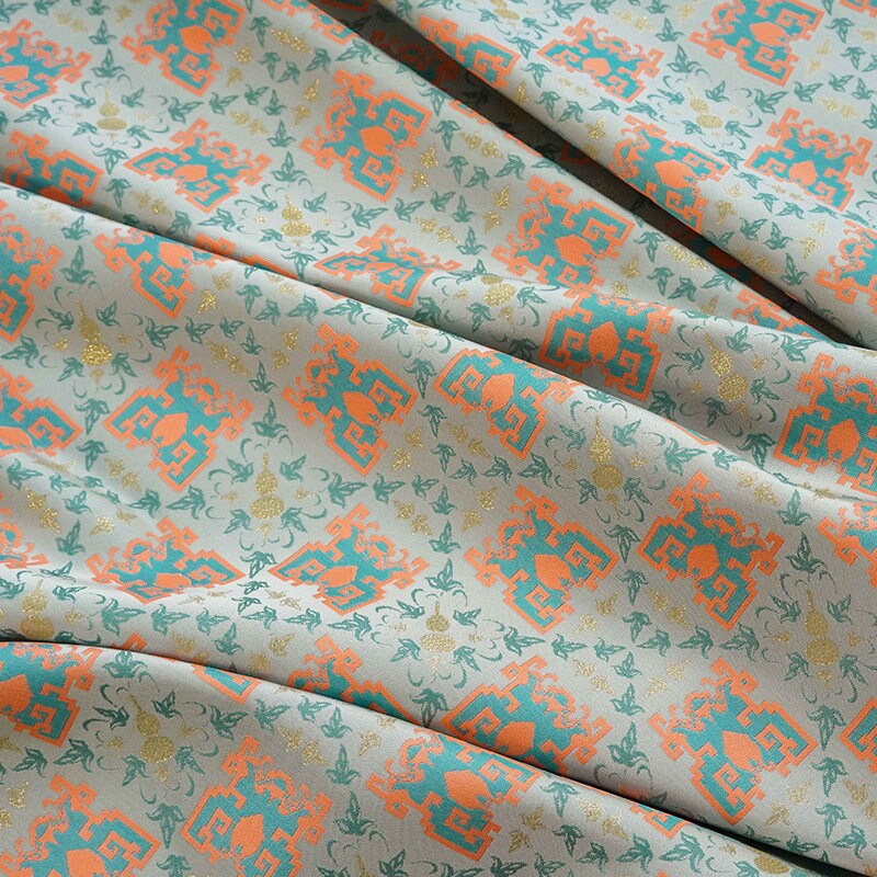 Tissu jacquard doré : motif totem asiatique ancien, 150 cm de large