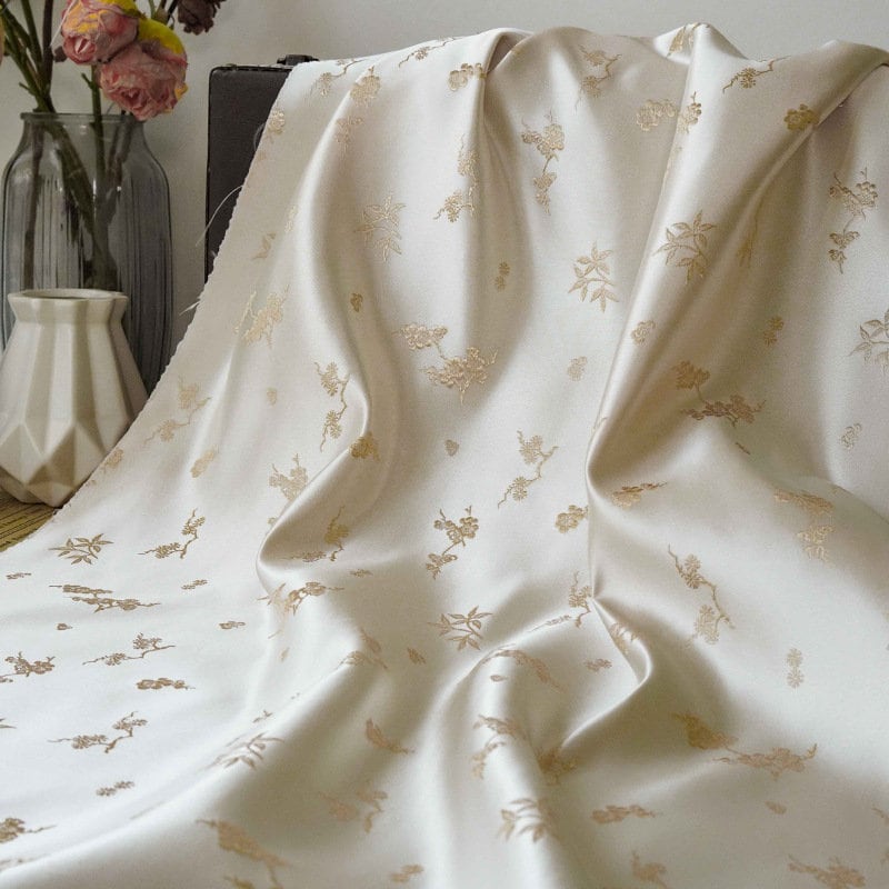 Tissu jacquard satiné ivoire : motif fleurs de prunier en relief, tissé, 165 cm de large