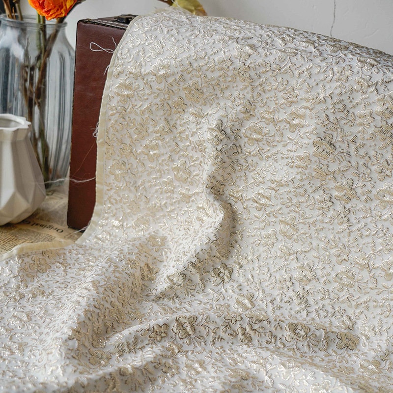 Tissu jacquard floral à fil doré : texture 3D, largeur 142 cm, pour l’ameublement et la confection de costumes.