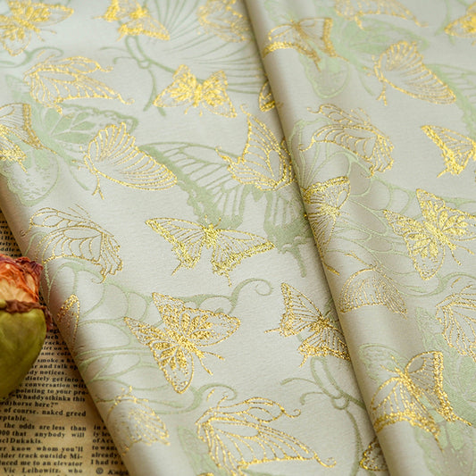 Tissu jacquard papillon doré : 150 cm de large, idéal pour les costumes.