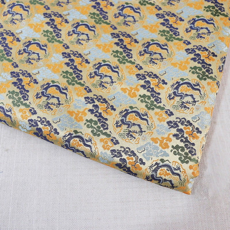Tissu brocart Dragon Argenté : mélange de rayonne de 150 cm de large, pour la confection de cheongsams.