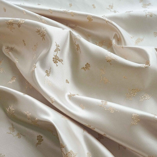Tissu jacquard satiné ivoire : motif fleurs de prunier en relief, tissé, 165 cm de large