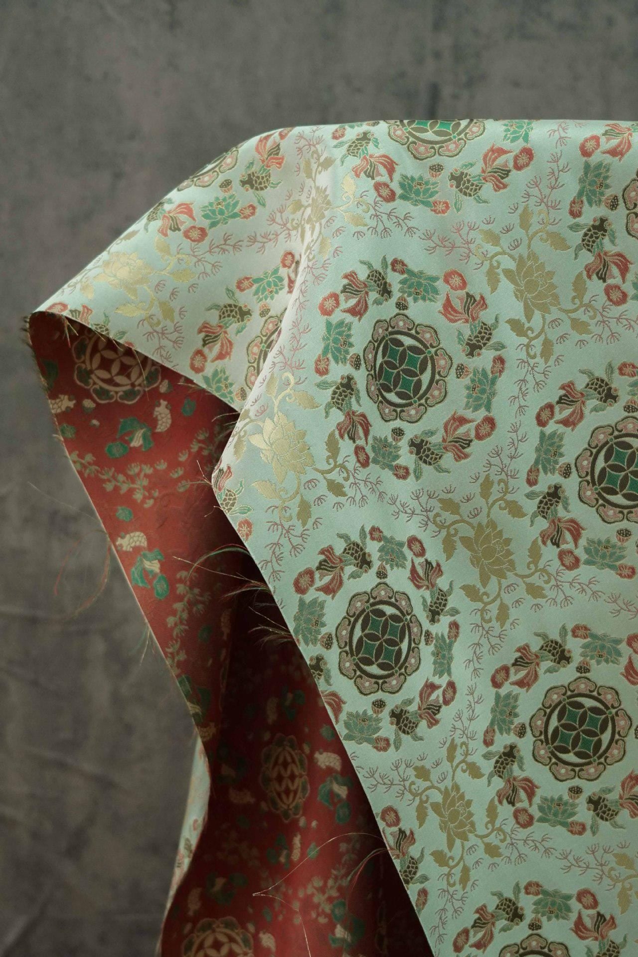 Tissu jacquard réversible bleu turquoise : motif poissons en relief, 165 cm de large