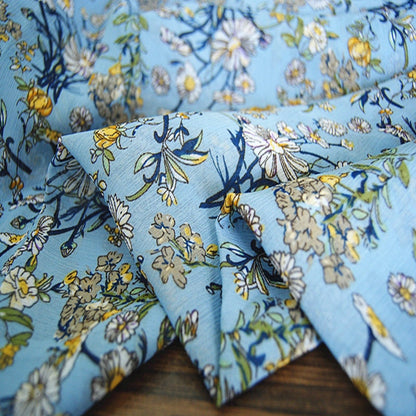 Crêpe bleu lac chrysanthème : 150 cm de large, satin de polyester, vendu au mètre