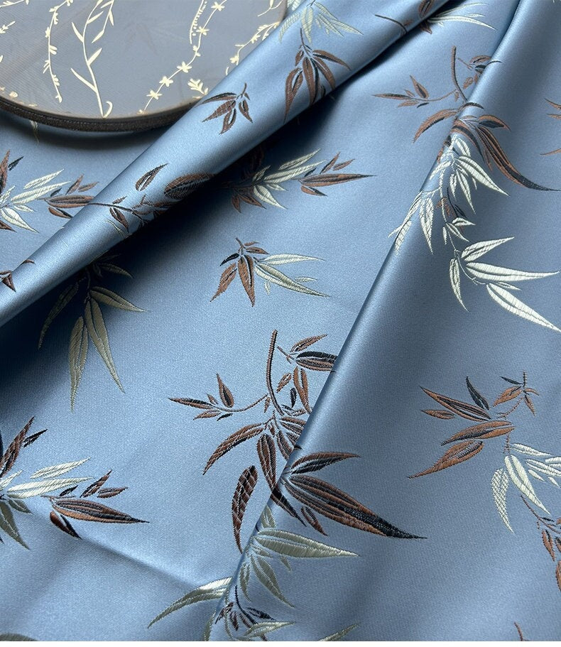 Tissu brocart de soie bleu ciel : feuilles et fleurs de bambou, accents métalliques dorés