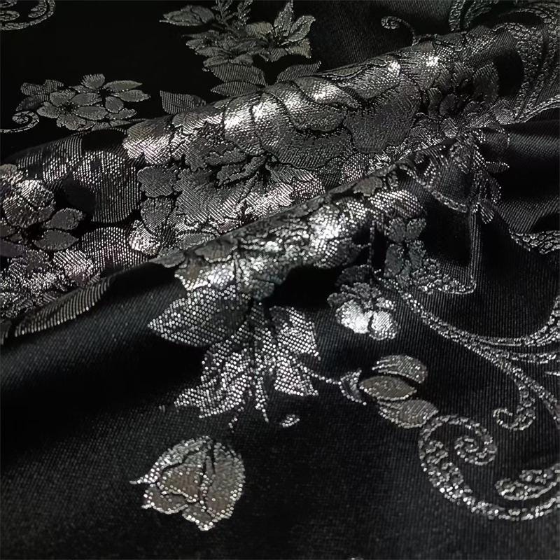 Tissu brocart jacquard noir : motif floral blanc nacré en relief, 150 cm de large