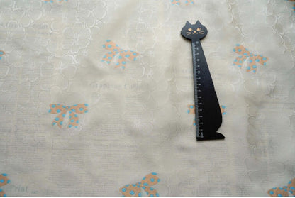 Tissu satin jacquard ivoire : motif nœud papillon, soyeux et lisse (165 cm de large)