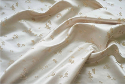 Tissu jacquard satiné ivoire : motif fleurs de prunier en relief, tissé, 165 cm de large