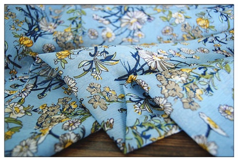 Crêpe bleu lac chrysanthème : 150 cm de large, satin de polyester, vendu au mètre