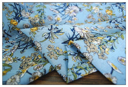 Crêpe bleu lac chrysanthème : 150 cm de large, satin de polyester, vendu au mètre