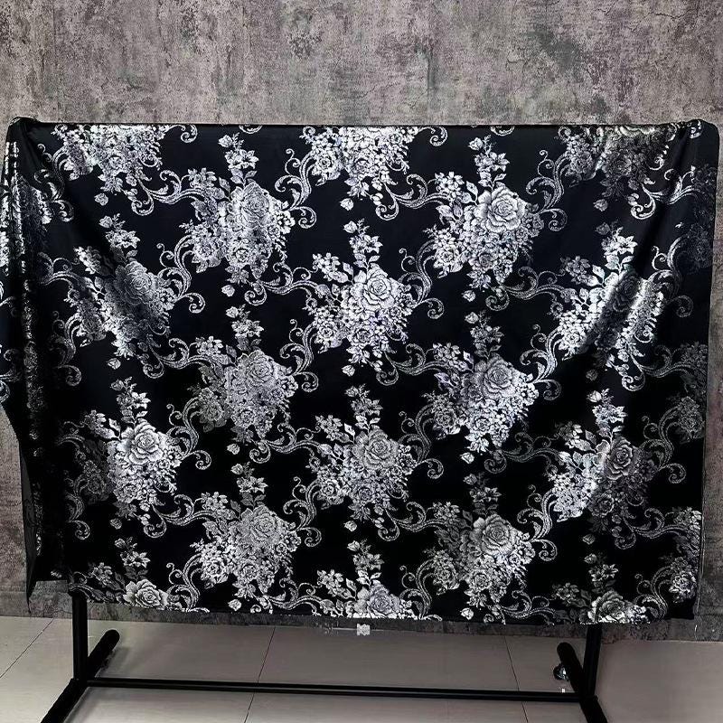 Tissu brocart jacquard noir : motif floral blanc nacré en relief, 150 cm de large