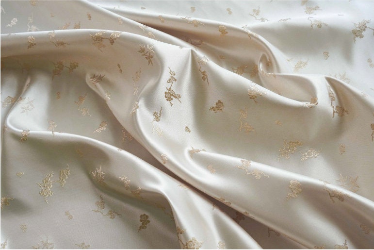Tissu jacquard satiné ivoire : motif fleurs de prunier en relief, tissé, 165 cm de large